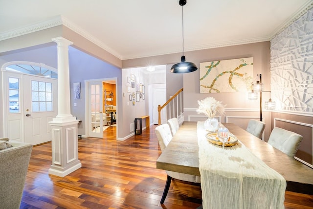 dining space featuring crown molding, dark wood-type flooring, and ornate columns