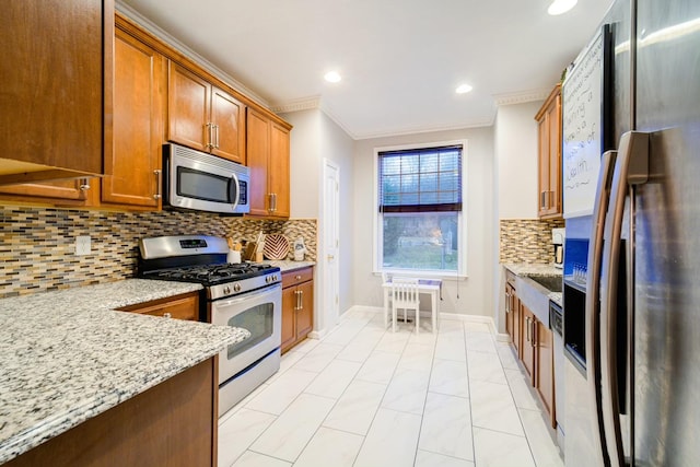 kitchen with light stone counters, ornamental molding, stainless steel appliances, and tasteful backsplash