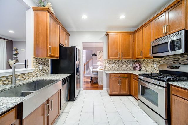 kitchen featuring light stone countertops, tasteful backsplash, ornamental molding, stainless steel appliances, and sink