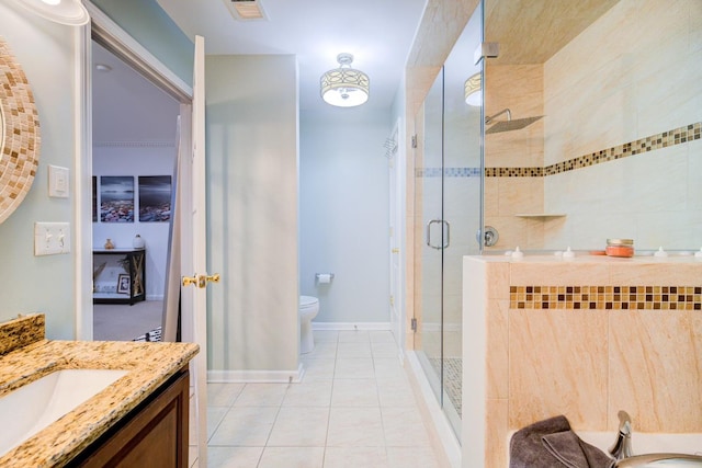 bathroom featuring tile patterned floors, vanity, toilet, and a shower with shower door