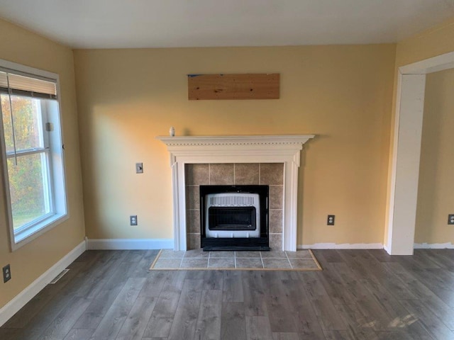 interior details with a tiled fireplace and hardwood / wood-style floors