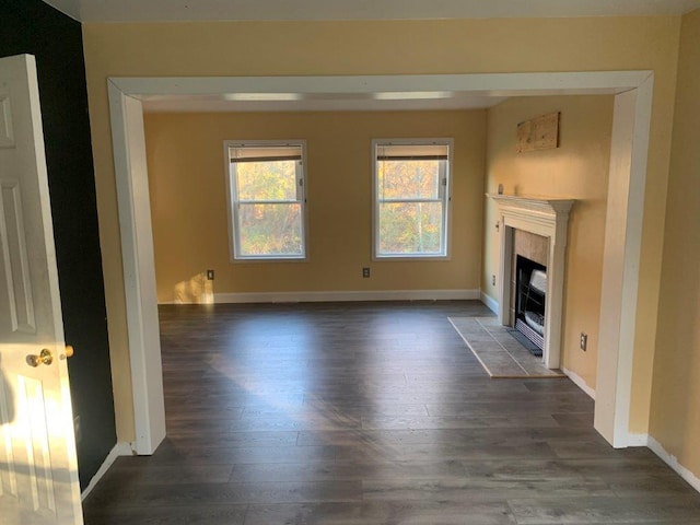 unfurnished living room featuring a fireplace and dark wood-type flooring