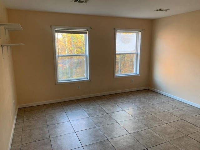 spare room with light tile patterned flooring and a healthy amount of sunlight