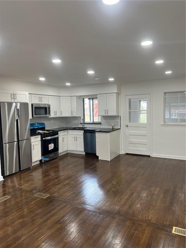 kitchen featuring refrigerator and white cabinets