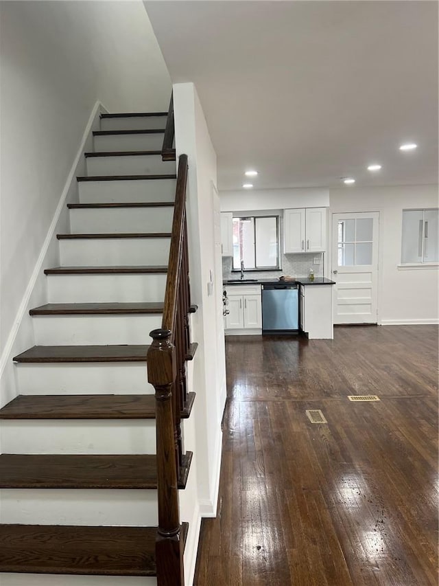 stairway with concrete flooring and wooden walls