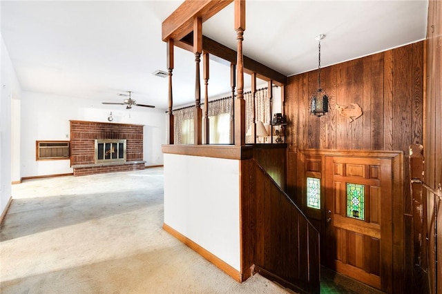 hallway with a wall unit AC, wooden walls, light colored carpet, and an inviting chandelier