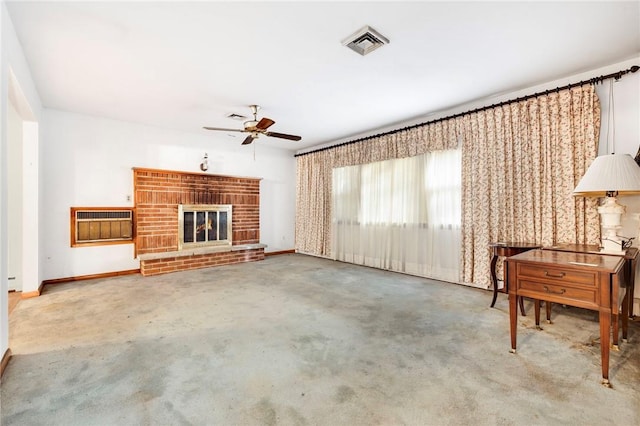 unfurnished living room featuring carpet flooring, a brick fireplace, ceiling fan, and a wall unit AC