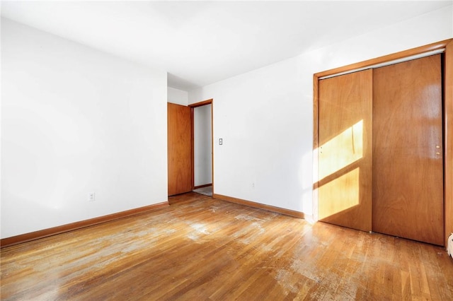 unfurnished bedroom featuring light hardwood / wood-style flooring and a closet