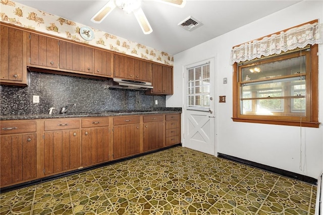 kitchen featuring backsplash, black cooktop, ceiling fan, and sink