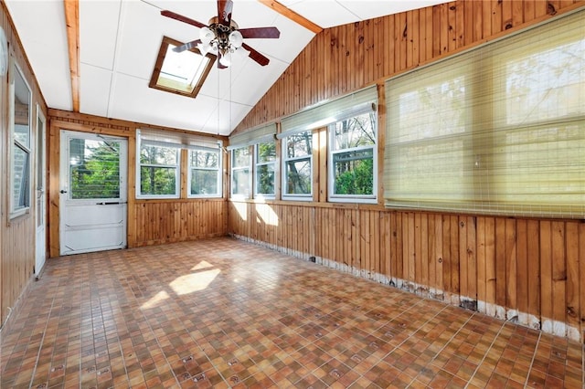 unfurnished sunroom featuring ceiling fan and vaulted ceiling with skylight