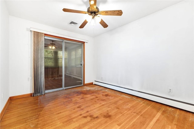 unfurnished room with hardwood / wood-style floors and a baseboard heating unit