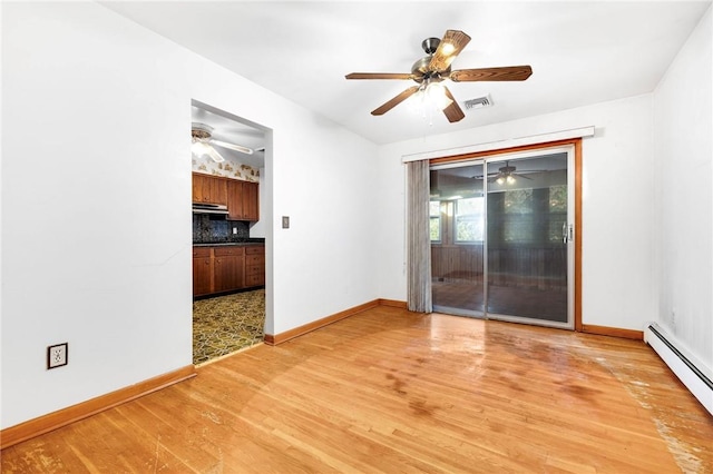 empty room featuring light hardwood / wood-style flooring and a baseboard radiator