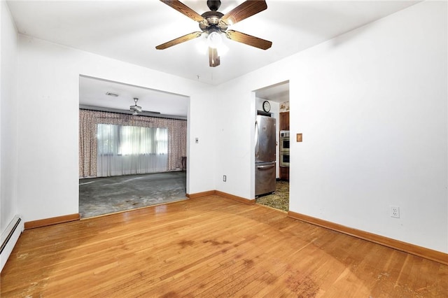 spare room featuring hardwood / wood-style floors, ceiling fan, and a baseboard radiator