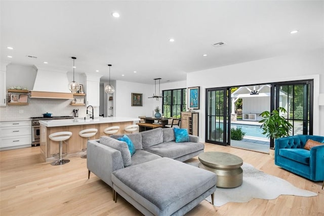 living room featuring sink and light hardwood / wood-style flooring