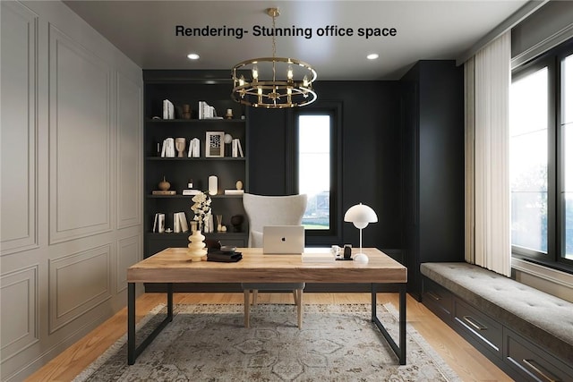 office area featuring an inviting chandelier, light hardwood / wood-style floors, and built in shelves