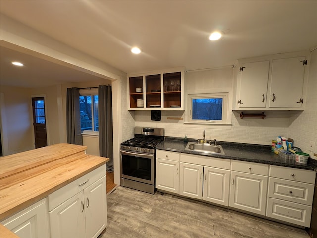 kitchen featuring white cabinetry, stainless steel gas stove, sink, light hardwood / wood-style flooring, and butcher block countertops