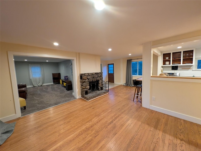 living room featuring light hardwood / wood-style floors and a stone fireplace