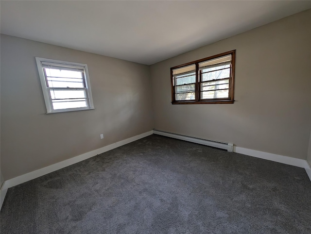 unfurnished room with dark colored carpet and a baseboard heating unit