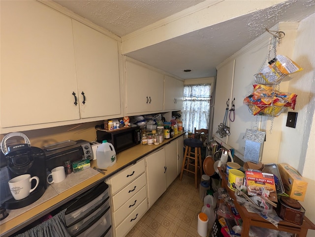 kitchen with white cabinets and a textured ceiling