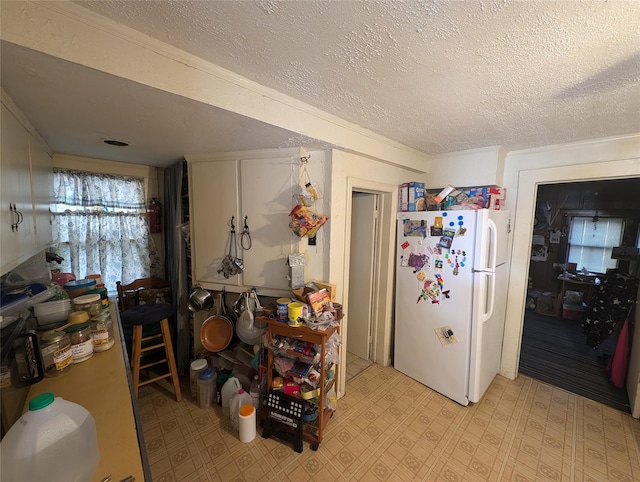 kitchen featuring a textured ceiling and white fridge