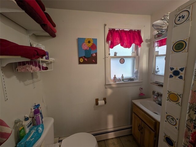 bathroom with hardwood / wood-style floors, vanity, toilet, and baseboard heating