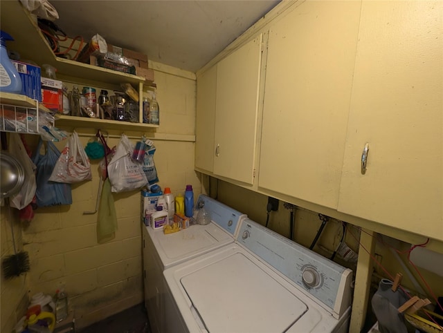 clothes washing area featuring washer and clothes dryer and cabinets