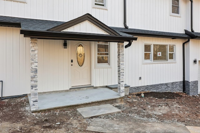 doorway to property featuring a shingled roof