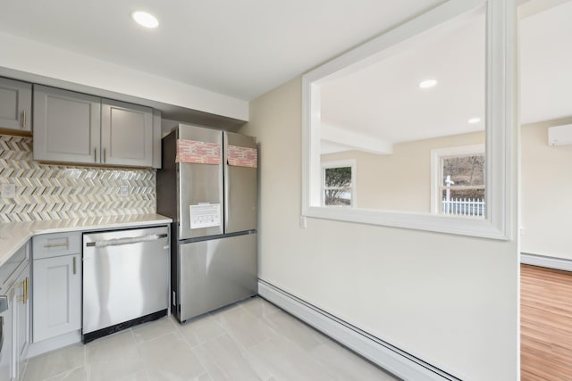 kitchen with stainless steel appliances, gray cabinets, light countertops, decorative backsplash, and a baseboard heating unit