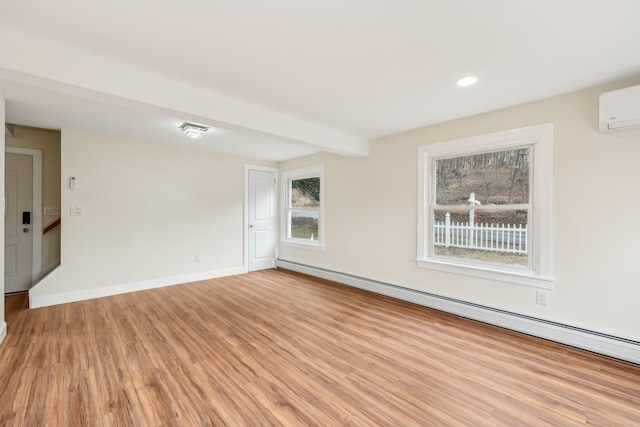 empty room featuring recessed lighting, a wall mounted AC, a baseboard heating unit, light wood-type flooring, and baseboards