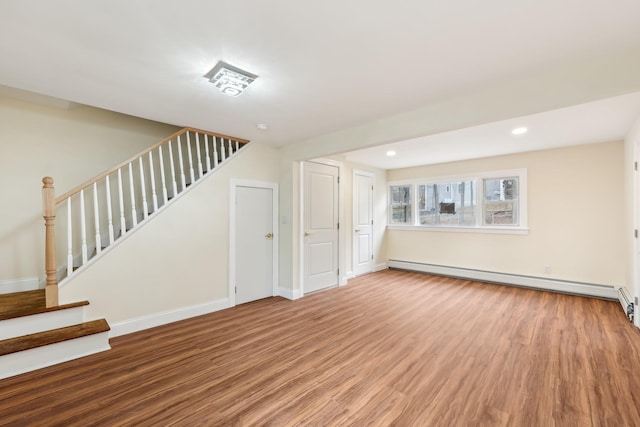 interior space with a baseboard radiator, stairs, baseboards, and wood finished floors