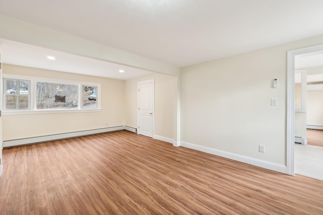 empty room featuring baseboards, baseboard heating, wood finished floors, and recessed lighting