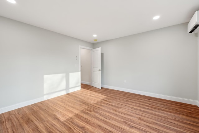 empty room with recessed lighting, light wood-style flooring, and baseboards