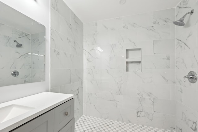 bathroom featuring a tile shower and vanity