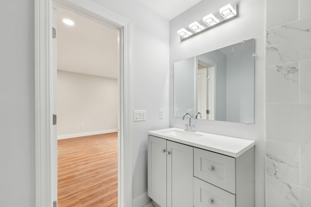 bathroom featuring baseboards, wood finished floors, and vanity