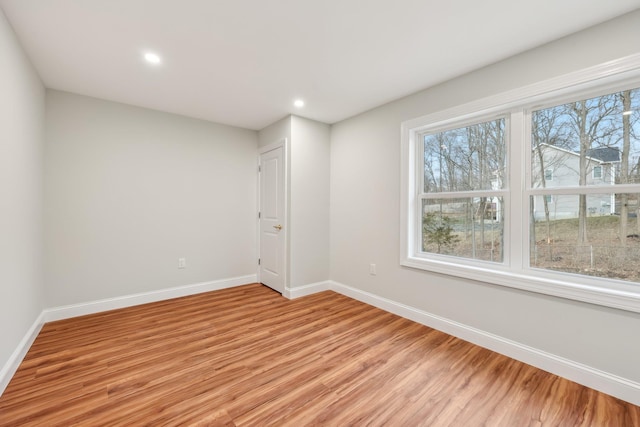 unfurnished room with light wood finished floors, recessed lighting, and baseboards