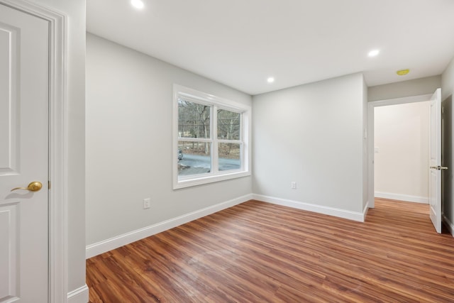 unfurnished bedroom featuring baseboards, wood finished floors, and recessed lighting