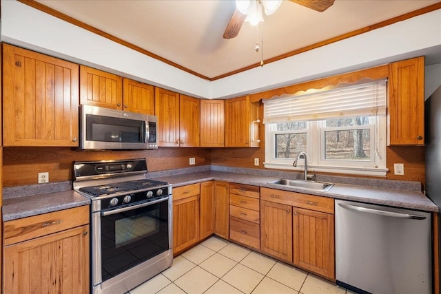 kitchen with crown molding, sink, ceiling fan, appliances with stainless steel finishes, and light tile patterned flooring