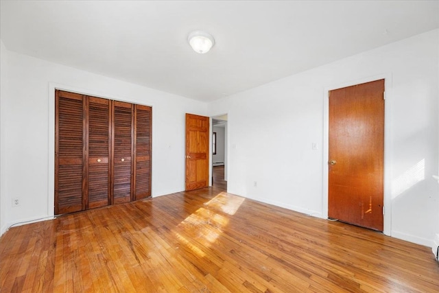 unfurnished bedroom with a closet and light hardwood / wood-style floors