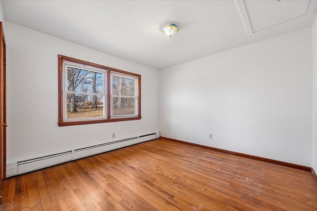 spare room featuring a baseboard radiator and light hardwood / wood-style flooring