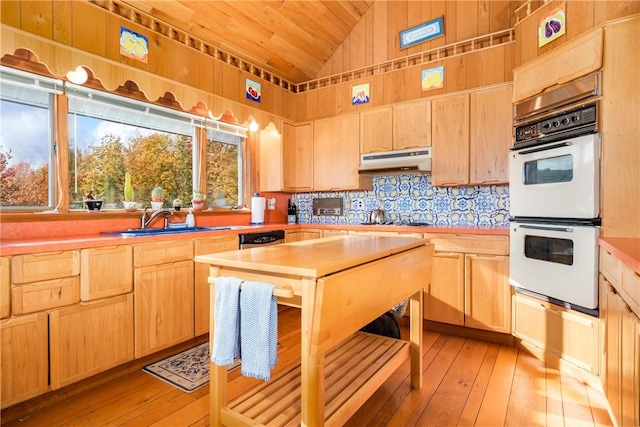 kitchen featuring lofted ceiling, sink, light hardwood / wood-style flooring, light brown cabinetry, and double oven