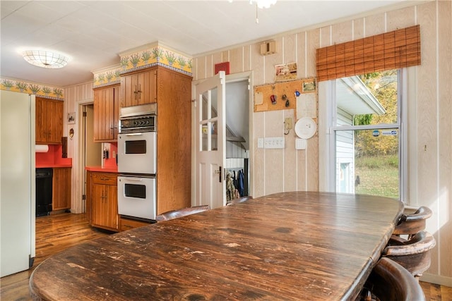 kitchen with hardwood / wood-style flooring, a healthy amount of sunlight, and white double oven