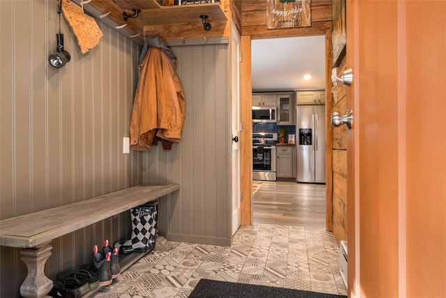 mudroom featuring light hardwood / wood-style floors and wood walls