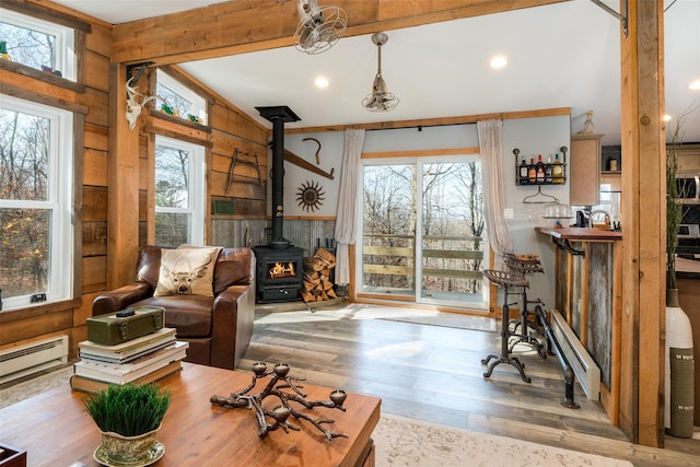 interior space featuring vaulted ceiling, a wood stove, and plenty of natural light