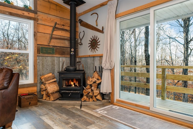 interior space featuring hardwood / wood-style floors, a wood stove, and wood walls