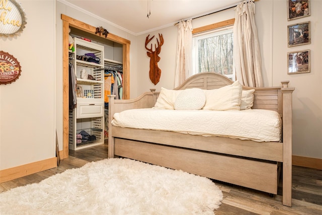 bedroom with hardwood / wood-style flooring, a closet, and ornamental molding