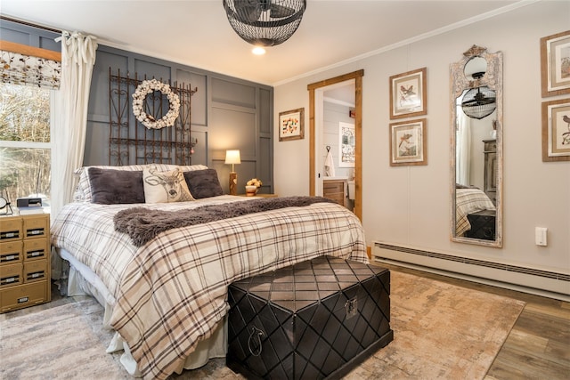 bedroom featuring ornamental molding, baseboard heating, and light hardwood / wood-style flooring