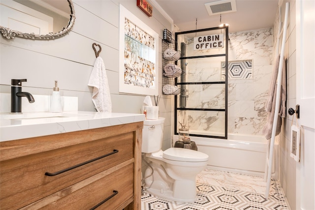 full bathroom with tile walls, vanity, tiled shower / bath combo, and toilet