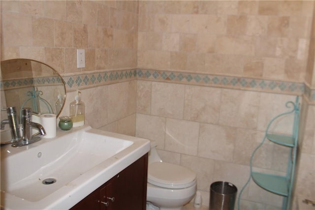 bathroom featuring vanity, toilet, and tile walls