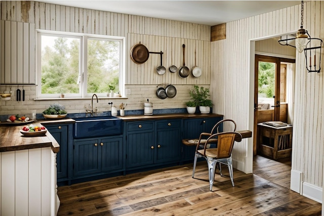 bar with plenty of natural light, a sink, and wood finished floors