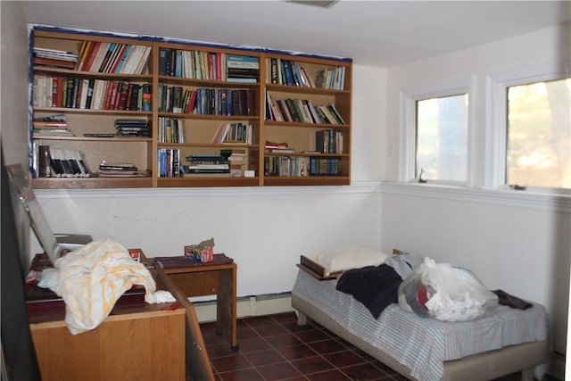 bedroom with a baseboard radiator and dark tile patterned floors